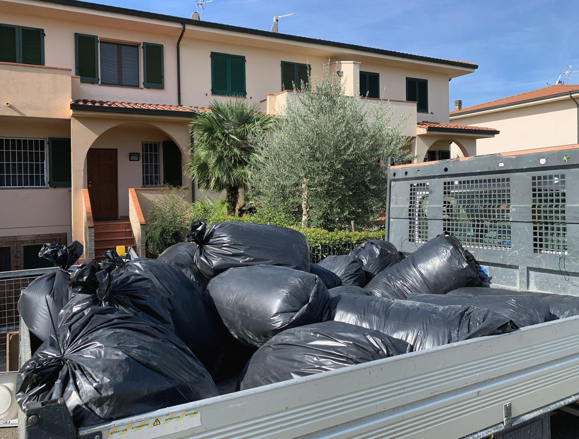 rubbish is being collected in a van parked in front of a house